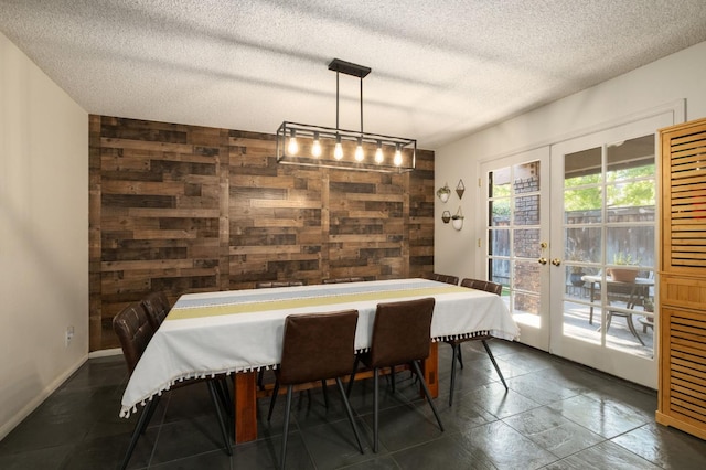 2063 W Barstow Ave, Fresno, CA 93711 - dining space with wood walls, a textured ceiling, french doors, and baseboards