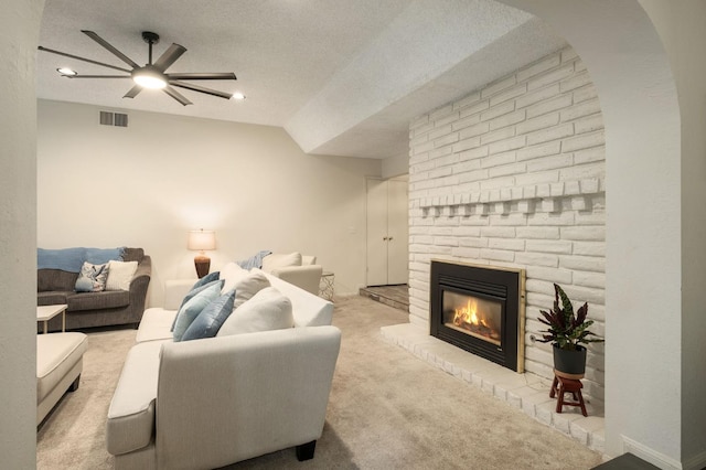 2063 W Barstow Ave, Fresno, CA 93711 - living area featuring a ceiling fan, carpet floors, a textured ceiling, a fireplace, and arched walkways