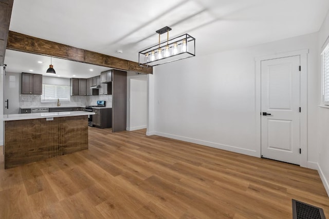 5075 N College Ave, Fresno, CA 93704 - kitchen with appliances with stainless steel finishes, light countertops, backsplash, wood finished floors, and dark brown cabinetry