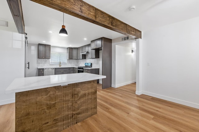 5075 N College Ave, Fresno, CA 93704 - kitchen with stainless steel appliances, light wood-style flooring, decorative backsplash, a sink, and baseboards