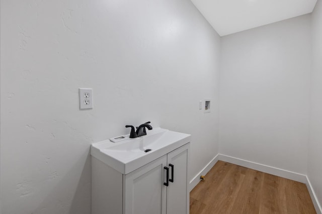 5075 N College Ave, Fresno, CA 93704 - laundry room with a sink, light wood-style flooring, washer hookup, and baseboards