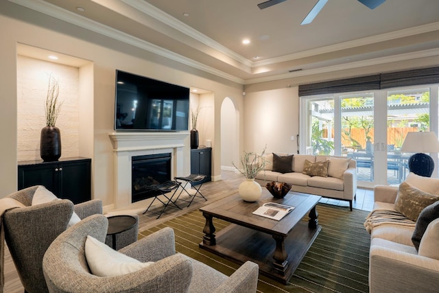 3343 Richmond Ave, Clovis, CA 93619 - living area with arched walkways, a ceiling fan, crown molding, wood finished floors, and a glass covered fireplace