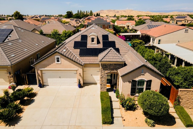 3343 Richmond Ave, Clovis, CA 93619 - view of front of house featuring stucco siding, a residential view, stone siding, solar panels, and driveway