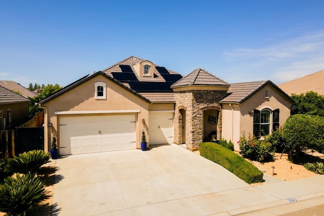 3343 Richmond Ave, Clovis, CA 93619 - view of front facade with stucco siding, stone siding, solar panels, and driveway