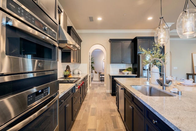 3343 Richmond Ave, Clovis, CA 93619 - kitchen with arched walkways, appliances with stainless steel finishes, ornamental molding, a sink, and light stone counters
