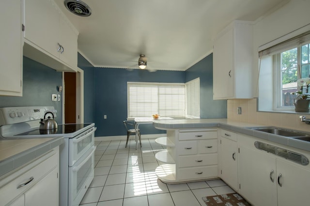 2837 N Thorne Ave, Fresno, CA 93704 - kitchen featuring range with two ovens, light tile patterned floors, tile counters, ceiling fan, and ornamental molding