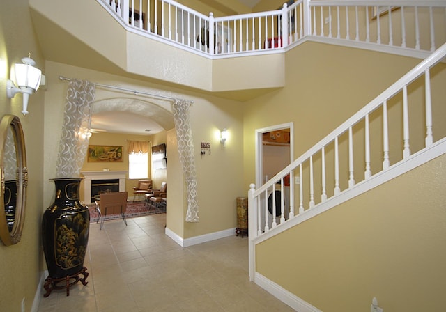 1756 N Holly Ave, Clovis, CA 93619 - foyer entrance with a high ceiling, a fireplace, arched walkways, tile patterned floors, and baseboards