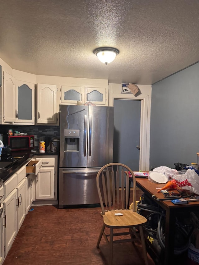 2316 S Eunice Ave, Fresno, CA 93706 - kitchen with stainless steel fridge with ice dispenser, dark countertops, white cabinets, dark wood-style flooring, and a textured ceiling