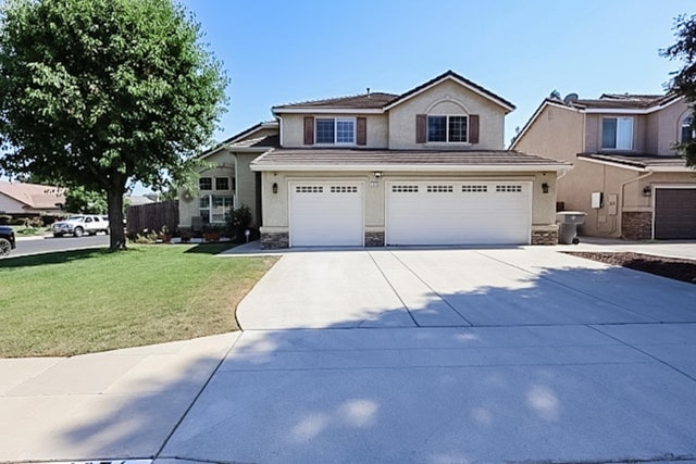 1976 Decatur Ave, Clovis, CA 93611 - traditional-style home featuring stucco siding, a garage, driveway, and stone siding