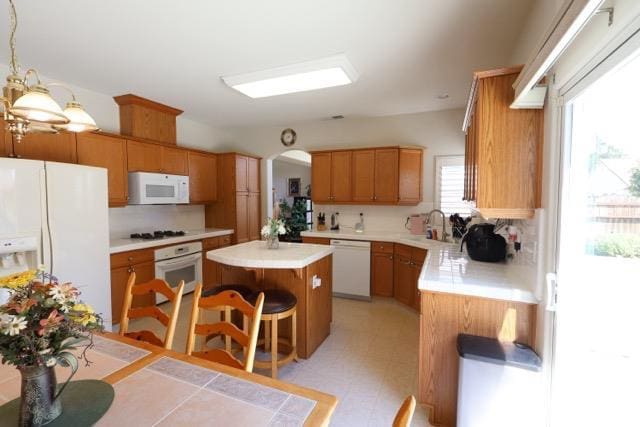 1976 Decatur Ave, Clovis, CA 93611 - kitchen with white appliances, a center island, tasteful backsplash, light countertops, and a kitchen breakfast bar