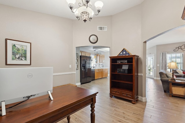 5860 W Menlo Ave, Fresno, CA 93722 - home office with a towering ceiling, arched walkways, a sink, a chandelier, and baseboards