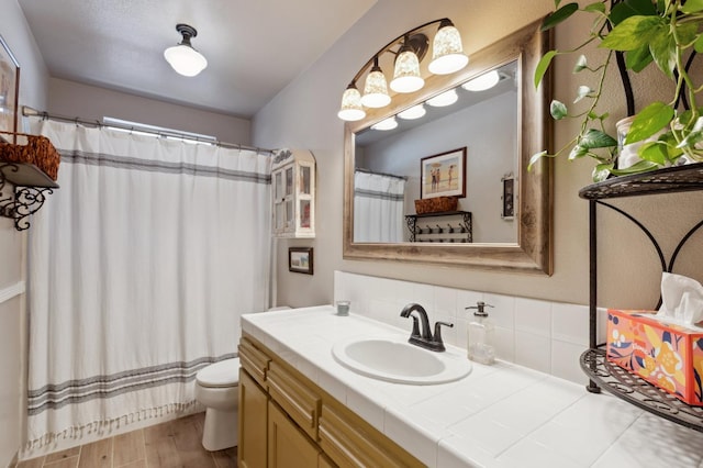 5860 W Menlo Ave, Fresno, CA 93722 - full bath with vanity, toilet, wood finished floors, and a shower with shower curtain