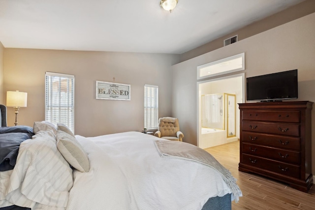 5860 W Menlo Ave, Fresno, CA 93722 - bedroom with light wood-type flooring, lofted ceiling, and ensuite bathroom
