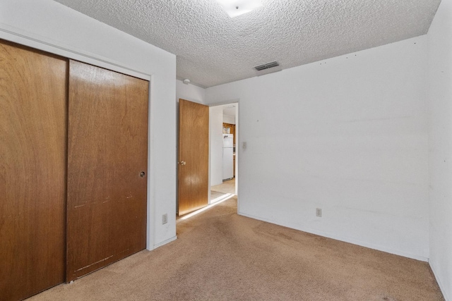 4782 W Austin Way, Fresno, CA 93722 - unfurnished bedroom with light colored carpet, a closet, a textured ceiling, freestanding refrigerator, and baseboards