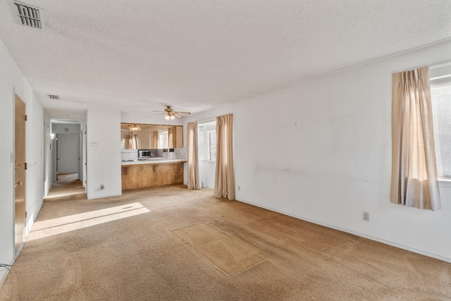 4782 W Austin Way, Fresno, CA 93722 - unfurnished living room with light colored carpet, a ceiling fan, and a textured ceiling
