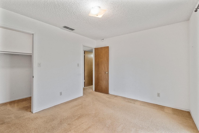 4782 W Austin Way, Fresno, CA 93722 - unfurnished bedroom with light carpet, a closet, a textured ceiling, and a walk in closet
