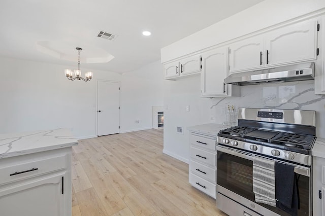 20434 Olympia Rd, Madera, CA 93638 - kitchen featuring stainless steel range with gas cooktop, under cabinet range hood, white cabinets, a chandelier, and light stone counters