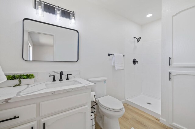 20434 Olympia Rd, Madera, CA 93638 - full bathroom with vanity, tiled shower, wood finished floors, toilet, and recessed lighting