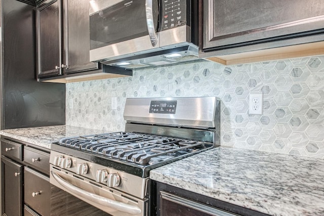 574 Expedition Way, Madera, CA 93636 - kitchen with stainless steel appliances, dark brown cabinetry, backsplash, and light stone countertops