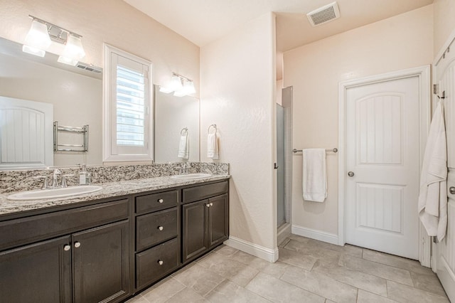 574 Expedition Way, Madera, CA 93636 - bathroom featuring double vanity, a stall shower, tile patterned flooring, and baseboards