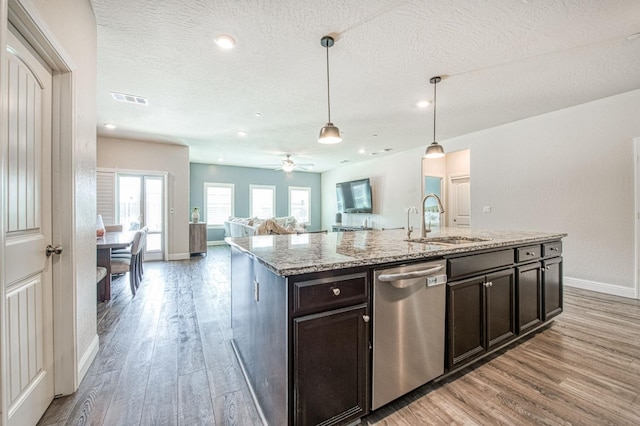 574 Expedition Way, Madera, CA 93636 - kitchen with dishwasher, a sink, light wood-style floors, baseboards, and light stone counters