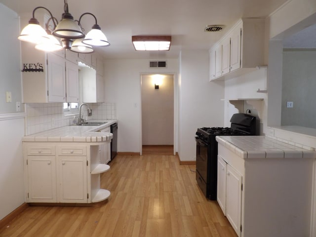 4321 Buckingham Way, Fresno, CA 93726 - kitchen featuring black gas range oven, tile counters, light wood-type flooring, tasteful backsplash, and white cabinets