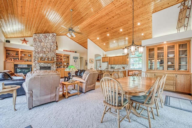42010 Granite Ledge Ln, Shaver Lake, CA 93664 - dining space featuring light carpet, wooden ceiling, a stone fireplace, high vaulted ceiling, and a ceiling fan