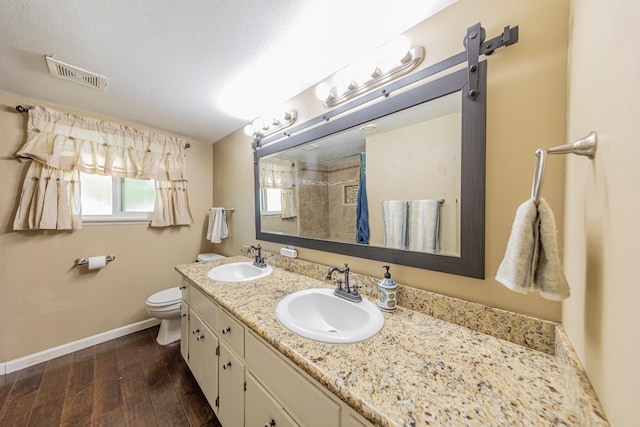 1096 Twain Ave W, Fresno, CA 93711 - full bath with double vanity, a tile shower, toilet, wood finished floors, and baseboards