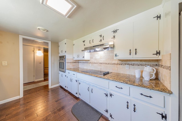 1096 Twain Ave W, Fresno, CA 93711 - kitchen featuring under cabinet range hood, black electric stovetop, oven, baseboards, and white cabinetry