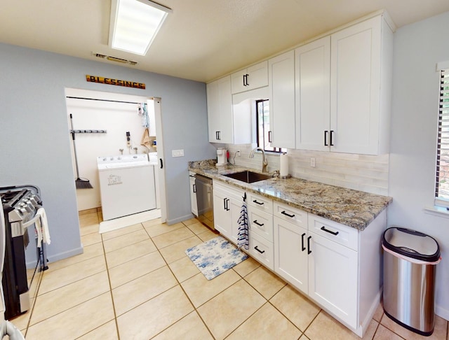 33491 Rd 233, North Fork, CA 93643 - kitchen featuring a sink, washing machine and clothes dryer, stainless steel appliances, tasteful backsplash, and white cabinetry