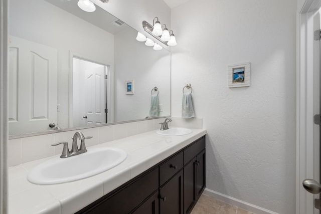 3771 Wrenwood Ave, Clovis, CA 93619 - bathroom featuring double vanity, baseboards, a textured wall, and tile patterned floors