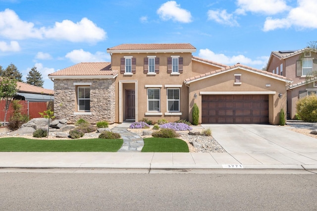 3771 Wrenwood Ave, Clovis, CA 93619 - mediterranean / spanish-style home featuring a tiled roof, stone siding, an attached garage, and stucco siding