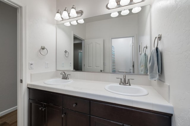 3771 Wrenwood Ave, Clovis, CA 93619 - full bath featuring double vanity, a textured wall, and wood finished floors