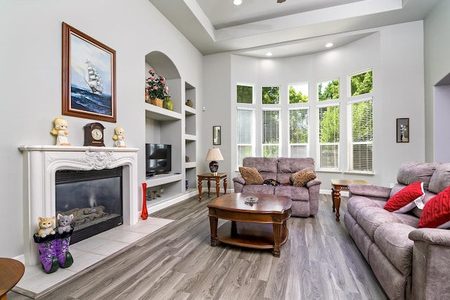 1413 N Hornet Ave, Clovis, CA 93619 - living area featuring built in features, wood finished floors, a glass covered fireplace, baseboards, and recessed lighting
