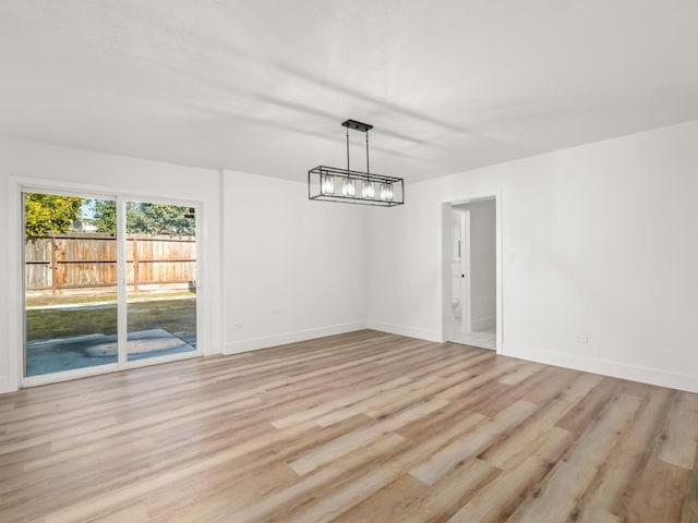 829 Polson Ave, Clovis, CA 93612 - unfurnished dining area with light wood finished floors, baseboards, and a chandelier