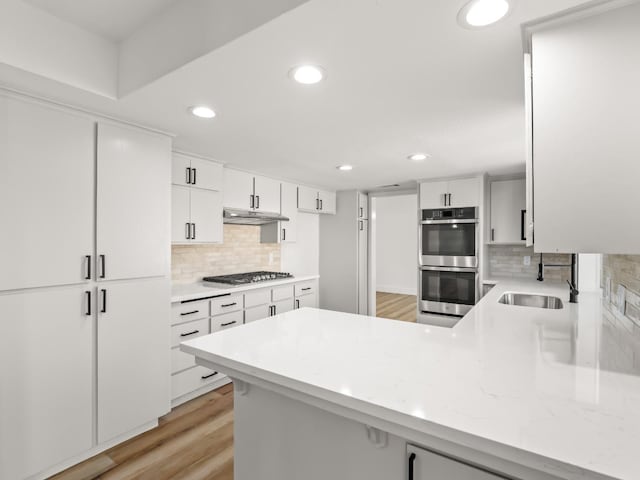 829 Polson Ave, Clovis, CA 93612 - kitchen with appliances with stainless steel finishes, a peninsula, decorative backsplash, a sink, and recessed lighting