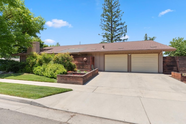 3244 W Fremont Ave, Fresno, CA 93711 - ranch-style house with board and batten siding, a garage, concrete driveway, and a chimney