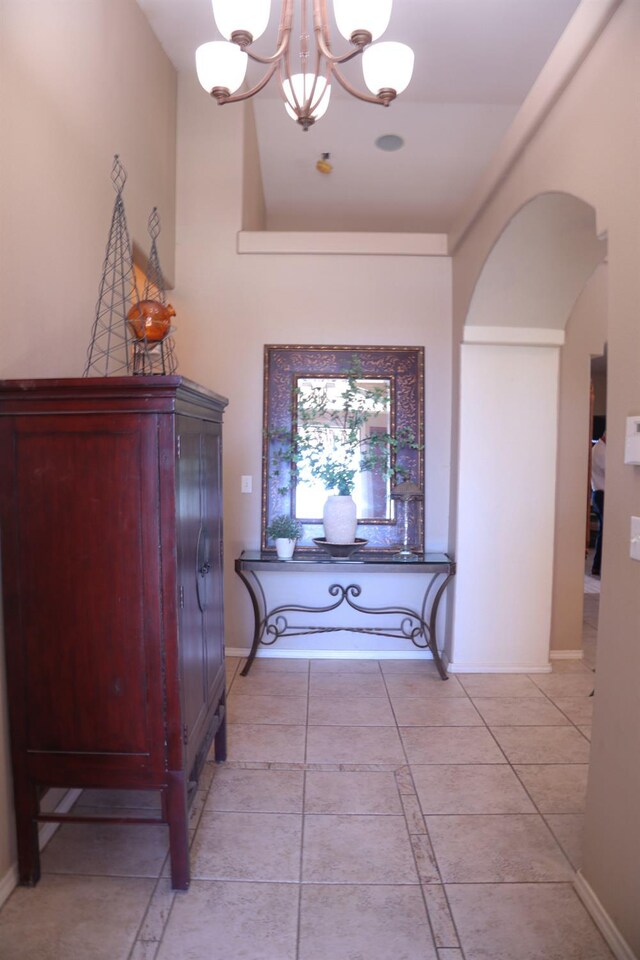 3055 Glenville Ave, Madera, CA 93637 - corridor with a chandelier, arched walkways, light tile patterned floors, and baseboards
