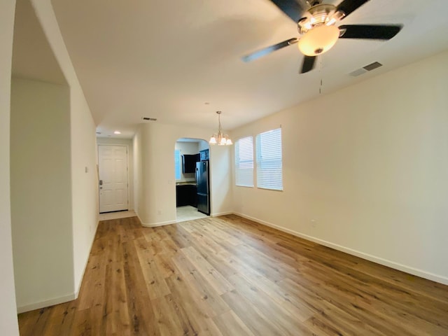 1507 N Strada Way, Clovis, CA 93619 - unfurnished living room with a chandelier, light wood-type flooring, ceiling fan, arched walkways, and baseboards