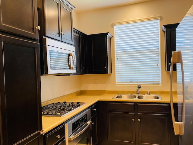 1507 N Strada Way, Clovis, CA 93619 - kitchen with appliances with stainless steel finishes, a sink, light countertops, and dark brown cabinetry