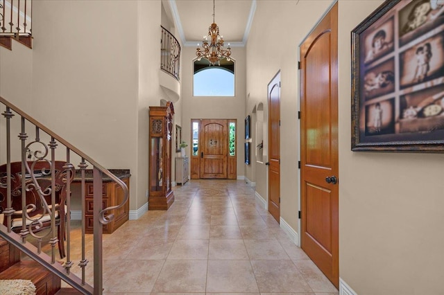 2707 W Menlo Ave, Fresno, CA 93711 - foyer entrance featuring crown molding, stairs, a chandelier, a high ceiling, and light tile patterned floors