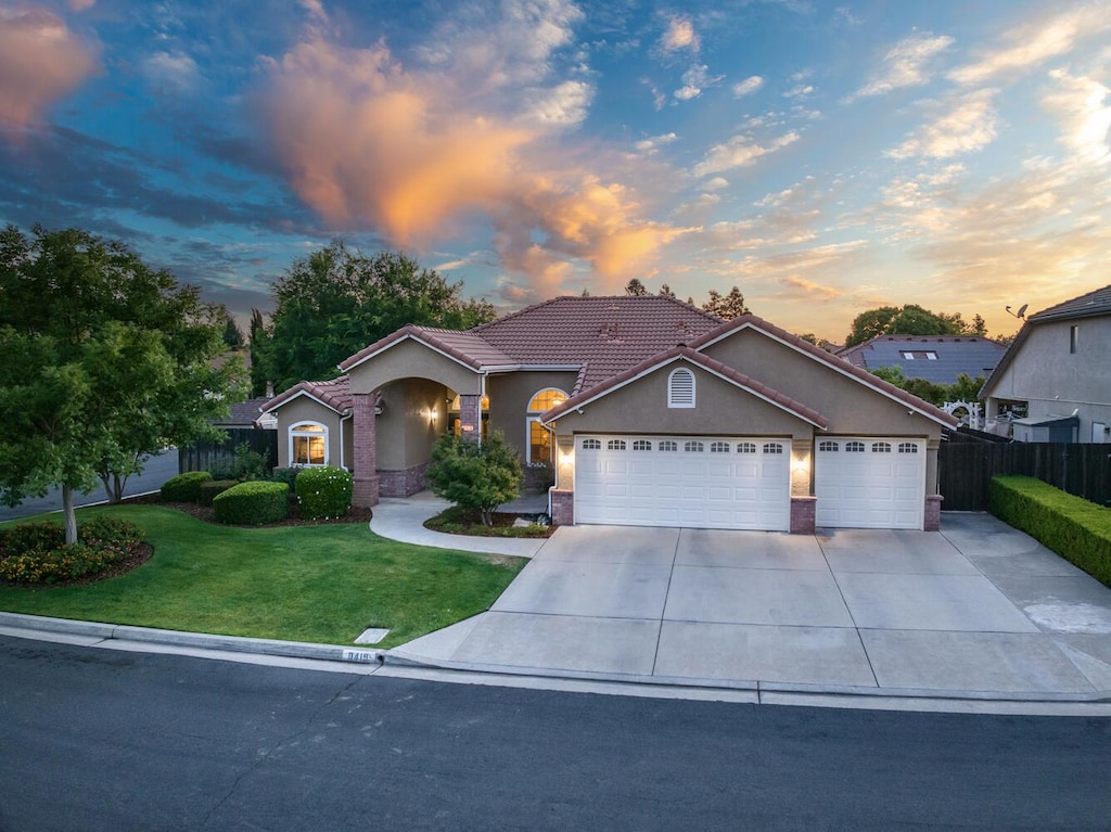 8419 N Whitney Ave, Fresno, CA 93720 - view of front of home featuring stucco siding, an attached garage, concrete driveway, and a tiled roof