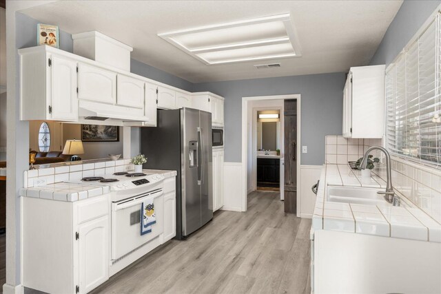 30015 Stetson Dr, Coarsegold, CA 93614 - kitchen with tile counters, a sink, white electric stove, black microwave, and white cabinets
