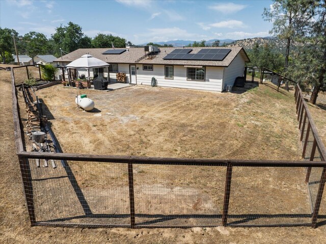 30015 Stetson Dr, Coarsegold, CA 93614 - rear view of house featuring a gazebo, a patio, roof mounted solar panels, and a fenced backyard