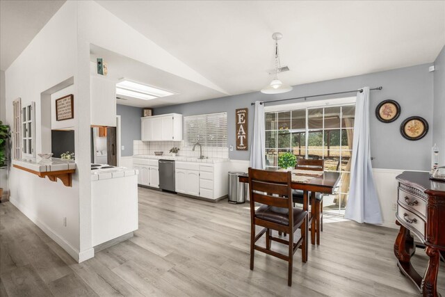30015 Stetson Dr, Coarsegold, CA 93614 - kitchen featuring stainless steel dishwasher, tile counters, a sink, white cabinetry, and light wood finished floors
