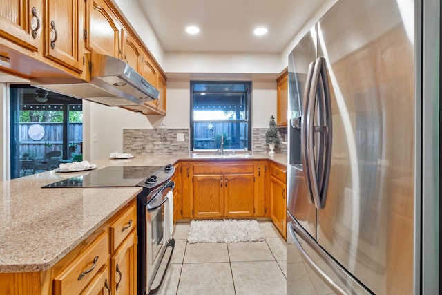 4633 N Glenn Ave, Fresno, CA 93704 - kitchen with appliances with stainless steel finishes, a sink, light tile patterned flooring, decorative backsplash, and brown cabinetry