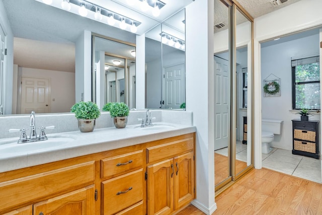 4633 N Glenn Ave, Fresno, CA 93704 - bathroom with double vanity, toilet, and wood finished floors