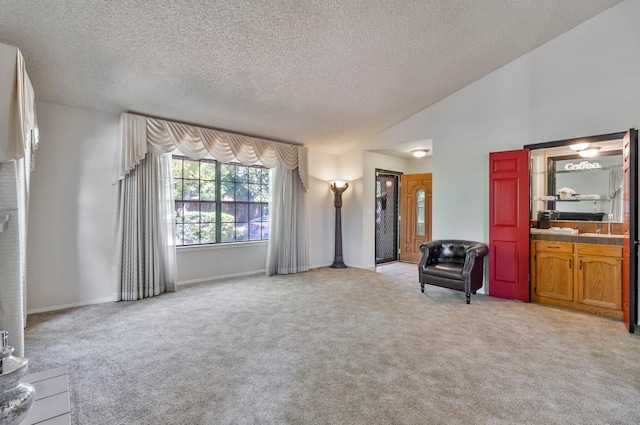 4633 N Glenn Ave, Fresno, CA 93704 - living room featuring a textured ceiling, light carpet, and vaulted ceiling