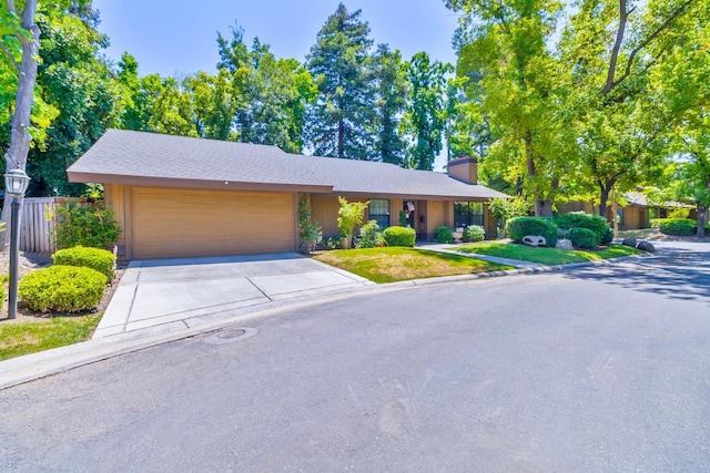 4633 N Glenn Ave, Fresno, CA 93704 - view of front of house with a chimney, a garage, and driveway