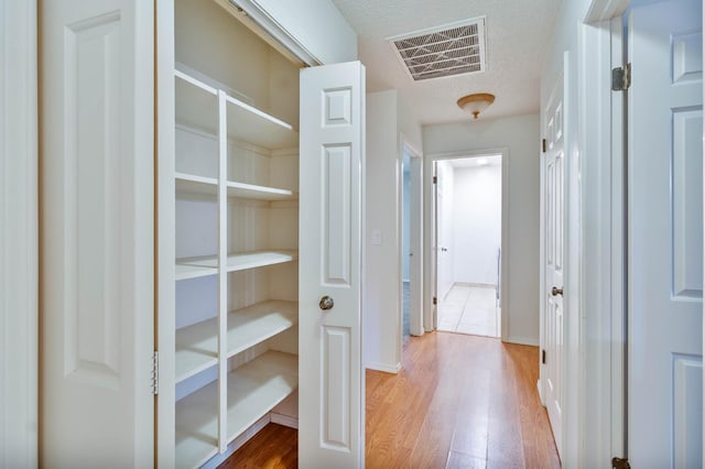 4633 N Glenn Ave, Fresno, CA 93704 - corridor with wood finished floors and a textured ceiling
